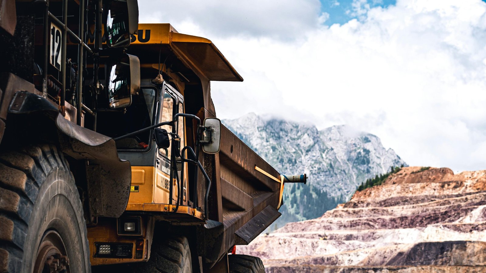 Large mining truck in a scenic mountain setting on a clear day.